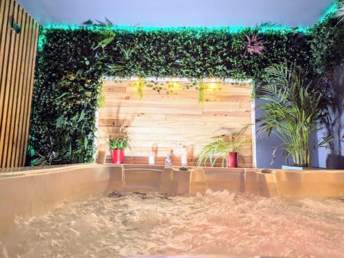 une pièce avec un mur végétal avec des plantes dessus dans l'établissement L'alcôve du 510 - Spa - chambre romantique - sauna - salle de jeux, à Montauban