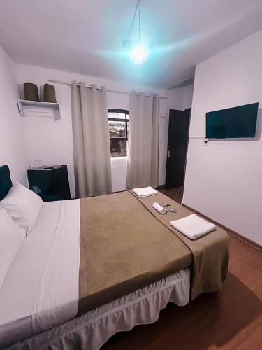 a bedroom with a large bed with two towels on it at Pousada Casa Recanto da Serra in Petrópolis