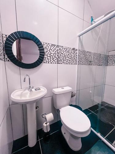 a bathroom with a toilet and a sink and a mirror at Pousada Casa Recanto da Serra in Petrópolis