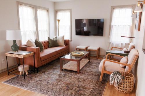 a living room with a couch and a table at The Elm House, Tranquil Getaway Close to Campus! in Norman
