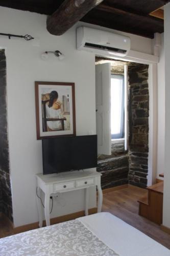 a bedroom with a bed and a desk in a room at Casa Amélia in Vila Nova de Foz Coa
