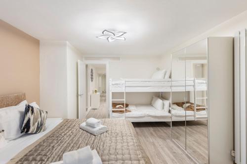 サウスエンド・オン・シーにあるModern 2 Bed Gem Southend on Sea Free parkingの白いベッドルーム(二段ベッド2組付)