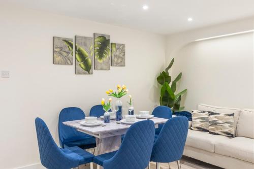 a dining room with blue chairs and a table at Modern 2 Bed Gem Southend on Sea Free parking in Southend-on-Sea