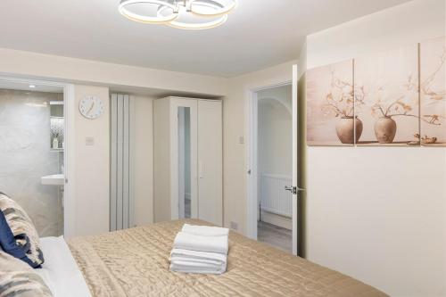 サウスエンド・オン・シーにあるModern 2 Bed Gem Southend on Sea Free parkingのベッドと壁に絵が飾られた寝室