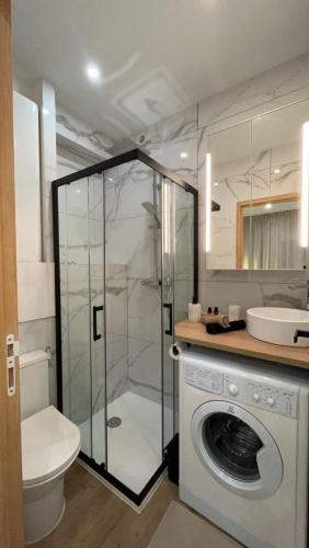 une salle de bain avec douche et machine à laver dans l'établissement Le nid des Carmes, à Toulouse