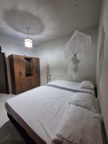 a bedroom with two twin beds and a cabinet at Casa familiar Rústica in Porto Seguro
