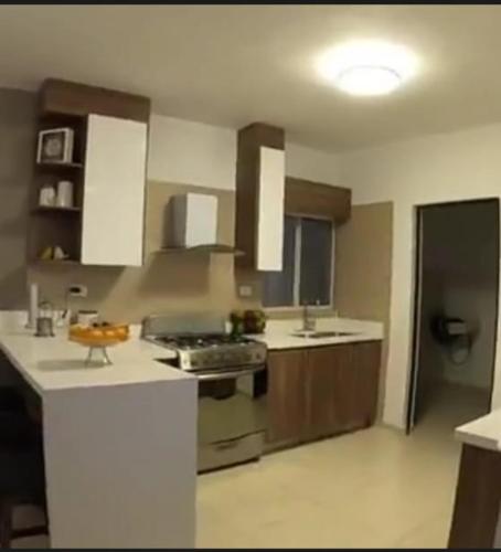 a large kitchen with white counter tops and brown cabinets at CasaDelRey in Saltillo