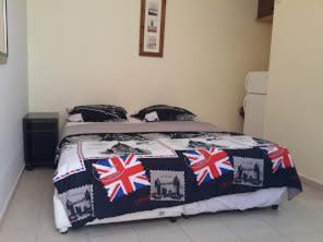 a bedroom with a bed with british flags on it at Rose Dead Sea Neve Zohar in Neve Zohar