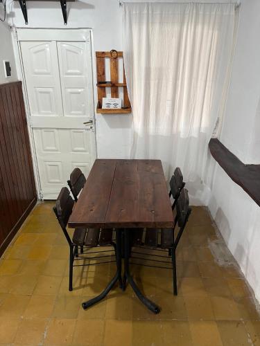 a wooden table and chairs in a room with a door at Dulce Claudina 2 in Mercedes