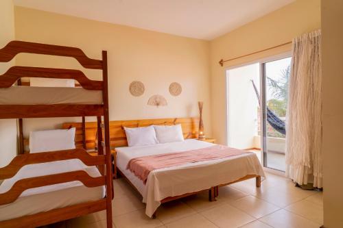 a bedroom with two bunk beds and a window at Pousada Villa Tomasi in Jericoacoara