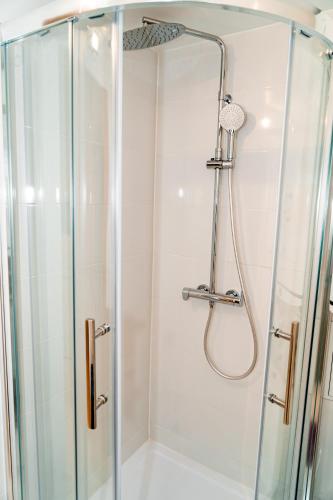 une douche avec une porte vitrée dans une salle de bain dans l'établissement Qhome 8 - T2 Cosy entre Paris & Disney, à Noisy-le-Grand