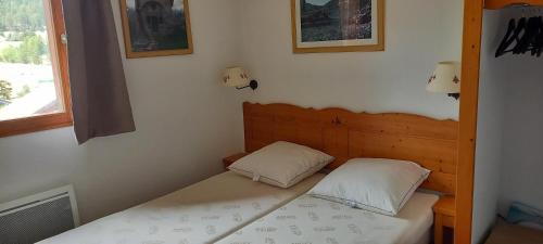 une petite chambre avec un lit et une fenêtre dans l'établissement Appartement Soleil Neige Dévoluy grand confort, à Saint-Étienne-en-Dévoluy