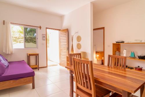 a dining room with a wooden table and chairs at Pousada Villa Tomasi in Jericoacoara