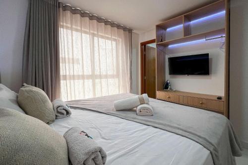 a bedroom with a large bed with towels on it at Apto Novinho Bessa 200m Praia 4 Pessoas in Nossa Senhora do Livramento