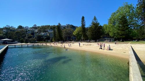 a group of people on a beach near a body of water at Bea's Cottage in Clontarf in Sydney