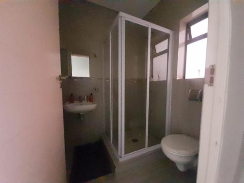 a bathroom with a shower and a toilet and a sink at Kidd's Beach in Kiddʼs Beach