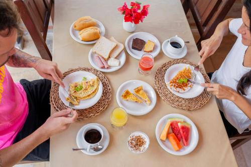 a group of people sitting at a table eating breakfast at Pousada Villa Tomasi in Jericoacoara
