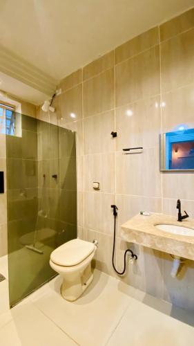a bathroom with a toilet and a shower and a sink at Studio espaço inteiro no centro de itumbiara in Itumbiara