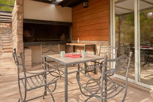 a table and chairs sitting on a patio at La Quebrada Potrerillos - Lodges de Montaña in Potrerillos