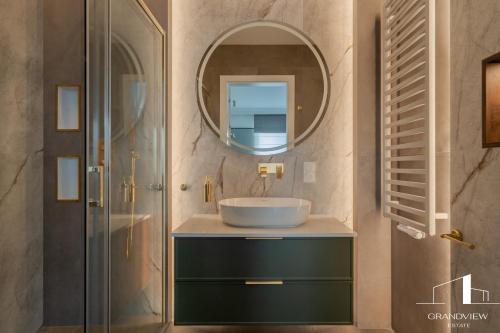 a bathroom with a sink and a mirror at Brabank Penthouse Old Town View, Sauna & Parking by Grandviewestate in Gdańsk