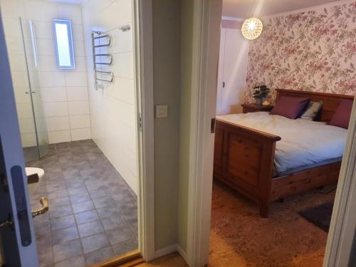 a bedroom with a bed and a door leading to a bathroom at Okidoki huset med welness in Hagfors