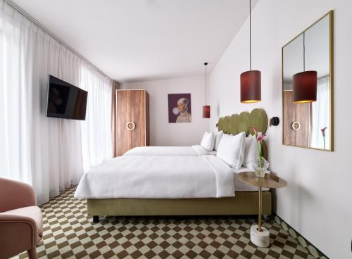 a bedroom with a large white bed and a couch at Hotel Pietryna in Łódź