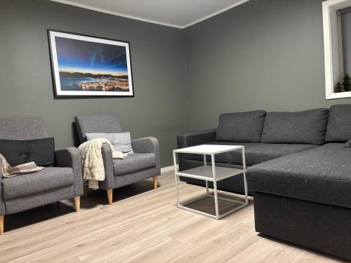 a living room with a couch and two chairs and a table at Tromso budget apartement in Tromsø
