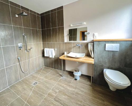 a bathroom with a shower and a toilet and a sink at Hôtel Le Littoral - Berck sur Mer in Berck-sur-Mer