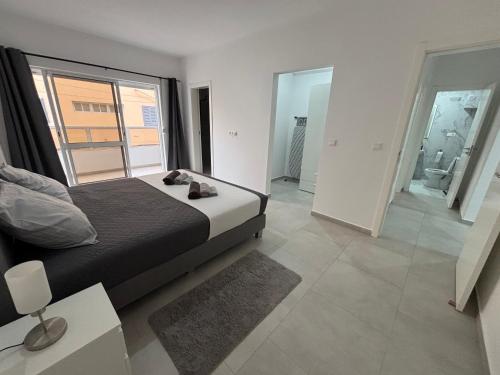 een slaapkamer met een bed en een groot raam bij Urban Mindelo in Mindelo