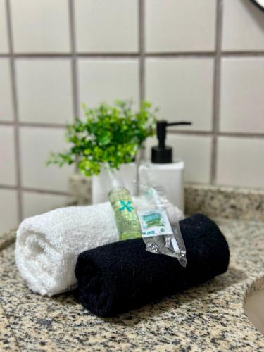 a black towel sitting on a bathroom counter with a toothbrush at (1002) Flat on Ponta da Areia Beach in São Luís