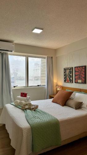 a bedroom with a large bed and a window at (1002) Flat on Ponta da Areia Beach in São Luís