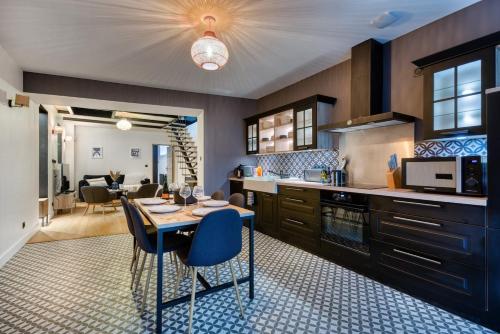 une cuisine avec une table et quelques chaises dans une pièce dans l'établissement Ocean Blue, à Concarneau