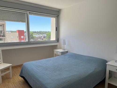 ein Schlafzimmer mit einem Bett und zwei Fenstern in der Unterkunft Amplio con vista al mar in Balneario Monte Hermosa