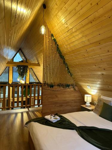 a bedroom with a bed in a wooden ceiling at Povestea din Munti in Arpaşu de Sus