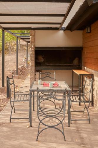 a table and chairs on a patio with a piano at La Quebrada Potrerillos - Lodges de Montaña in Potrerillos