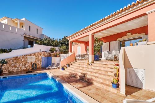 a villa with a swimming pool and a house at Casa Verao in Estômbar