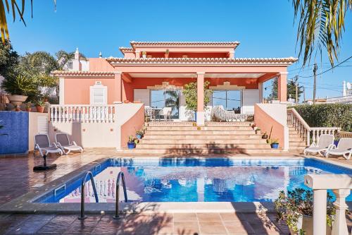 a villa with a swimming pool in front of a house at Casa Verao in Estômbar