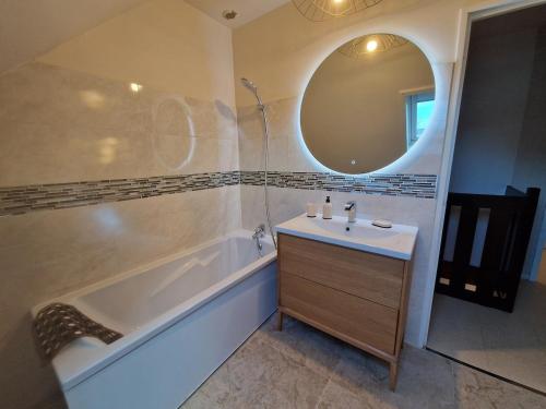 une salle de bain avec une baignoire, un lavabo et un miroir dans l'établissement Charming Home, à Hérouville-Saint-Clair