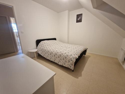 une chambre avec un lit dans une pièce blanche dans l'établissement Charming Home, à Hérouville-Saint-Clair