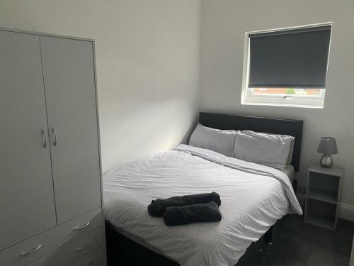 a bed with a pair of shoes sitting on it at Spacious 4 Bedroom Townhouse in Leeds