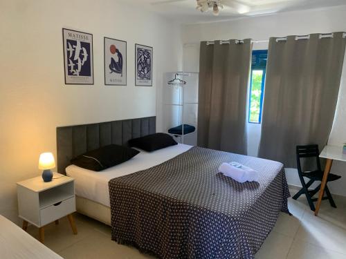 a bedroom with a bed with a black and white comforter at Pousada Casa da Penha in Abraão
