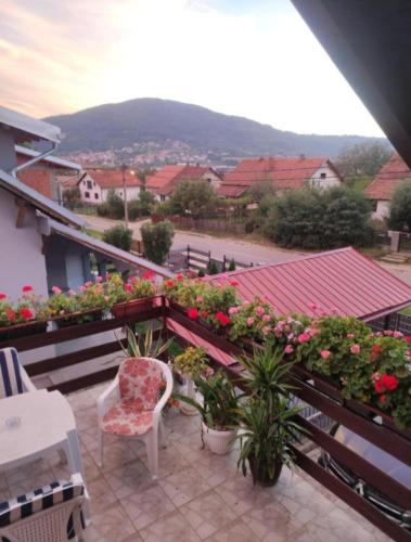 a balcony with a chair and flowers on a building at Jezero in Arandjelovac