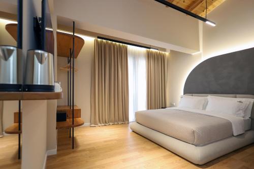 a bedroom with a white bed and a large window at Beratinus1 in Berat