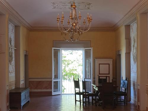 a dining room with a chandelier and a table and chairs at Locanda Corte Roveri in Bologna