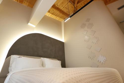 a bedroom with a white bed with a black headboard at Beratinus1 in Berat