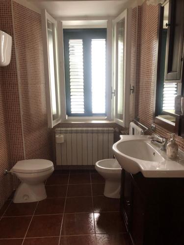 a bathroom with a toilet and a sink and a window at Giora House in Capracotta