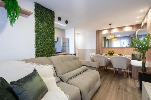 a living room with a couch and a table at Apartamentos em Bal Piçarras 150 M DA PRAIA com Sacada Wi Fi, Piscina, Portaria 24h, Playground e vaga de GARAGEM in Piçarras