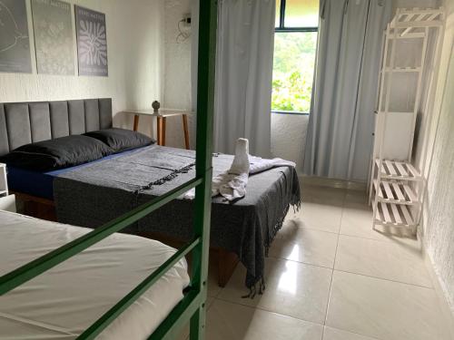 a bedroom with two beds and a window at Pousada Casa da Penha in Abraão