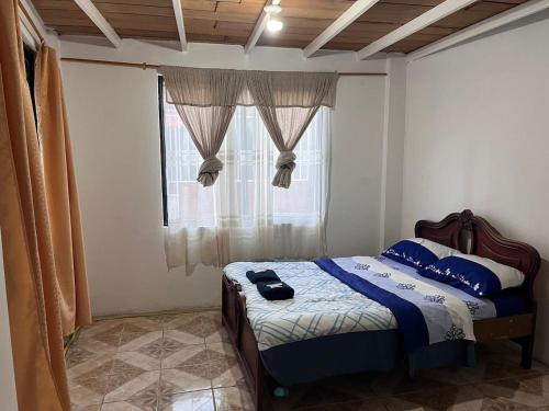 a bedroom with a bed and a window at Residencia Las Colinas in Juivi
