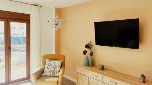 Una sala de estar con un televisor de pantalla plana en la pared. en Céntrico y amplio piso en Béjar, en Béjar